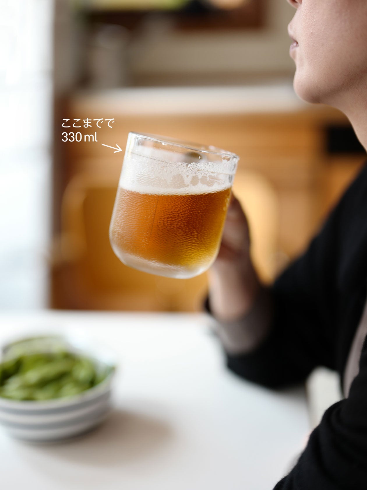 女性がKrouvi ビアグラス 330mlを持ってビールを飲んでいる写真