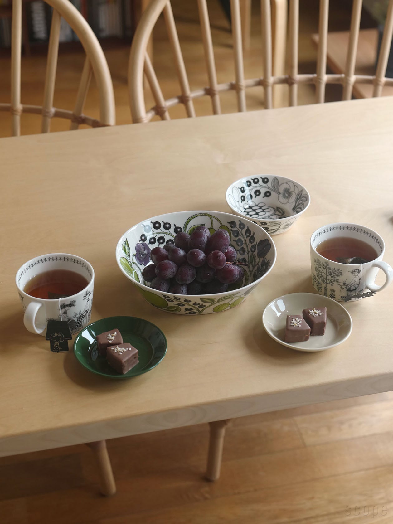 Paratiisiオーバルボウル23cmにブドウ、Teemaプレート12cmにチョコ菓子、Emiliaカップ0.4Lに紅茶のティータイム