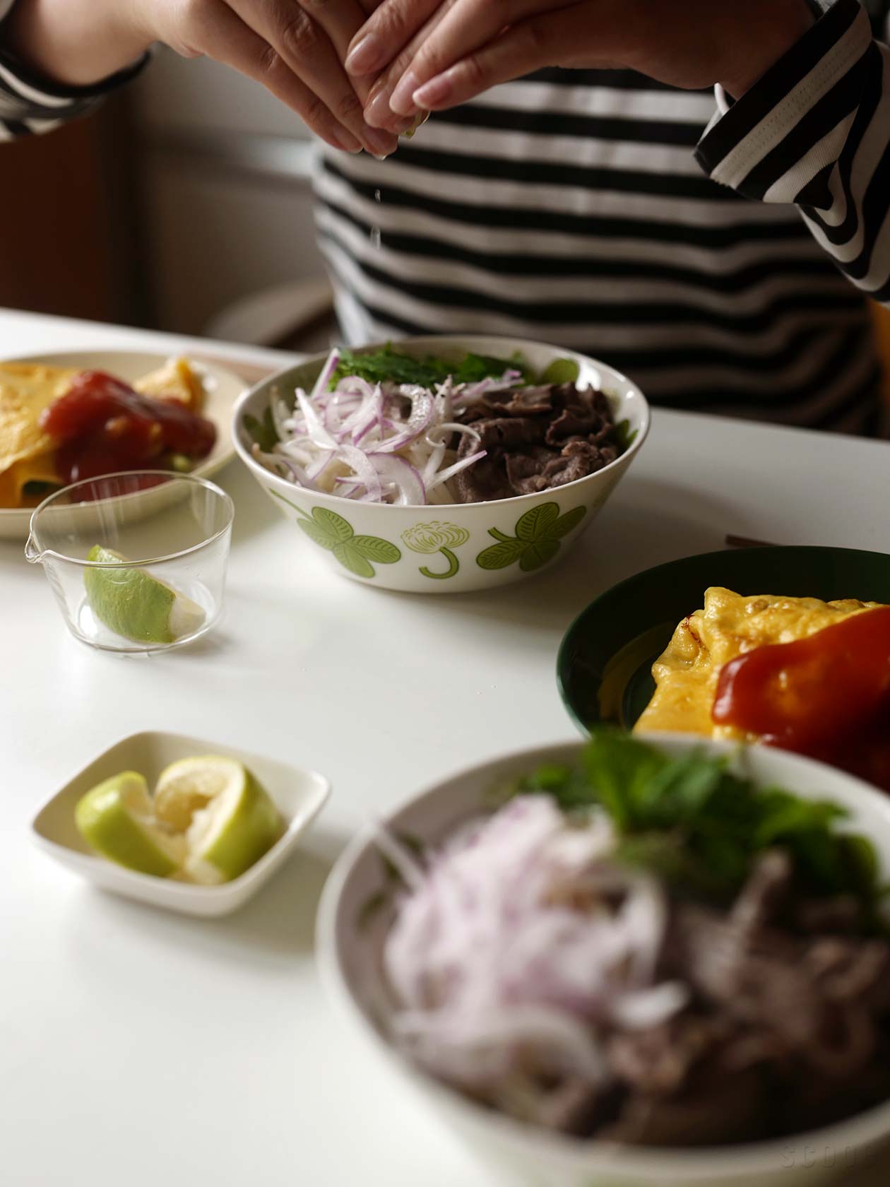 Apilaボウル17cmに盛りつけた牛肉のフォーにライムを絞っているところ。小ぶりな麺類を食べるにはいいサイズ