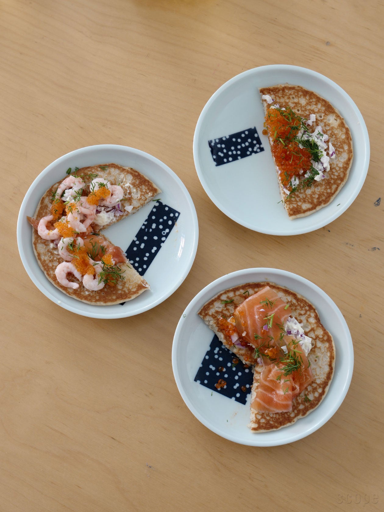 ブリニを盛り付けた平丸 窓に雪のプレート