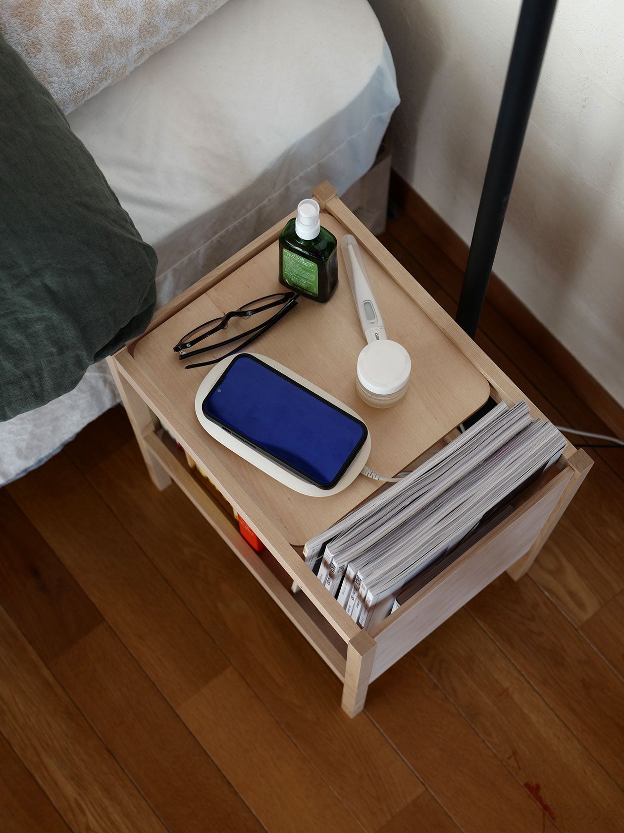 ベッド横に置かれたサイドテーブル。下段には充電コードなども収納可能