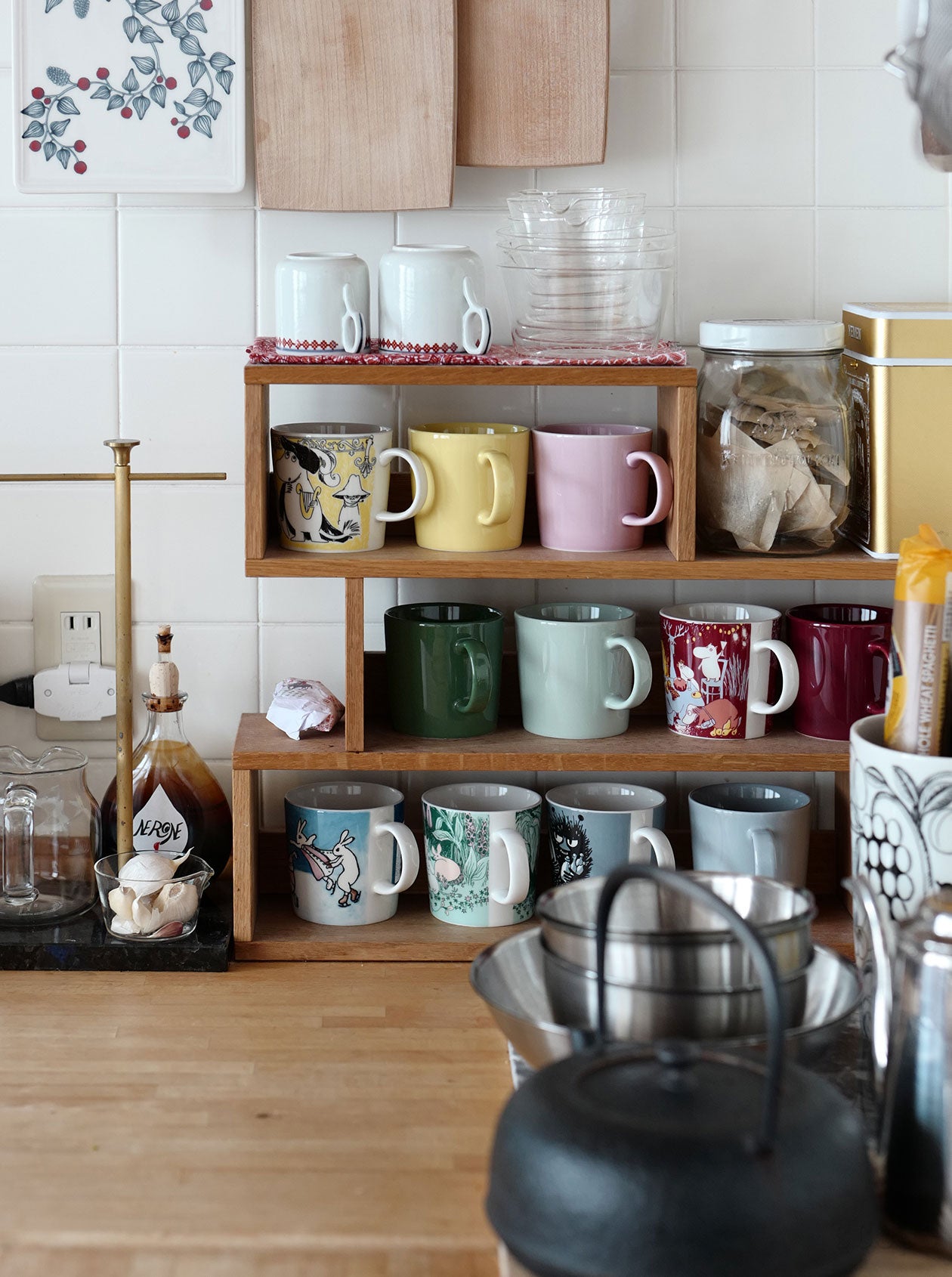 ティーラックに整然と並べられた色とりどりのマグカップ