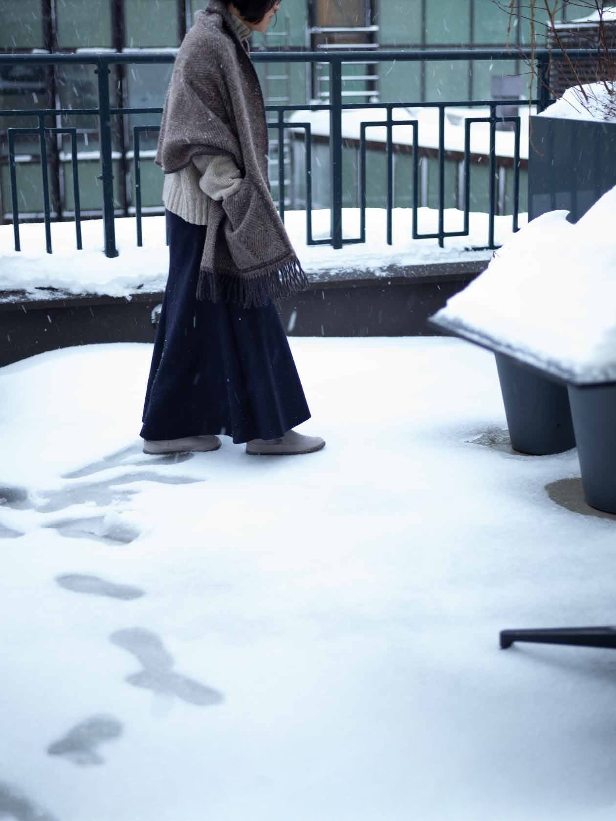ショール ウィズ ポケット Maria ブラウン×ブラックを羽織って雪のなかを歩いているところ