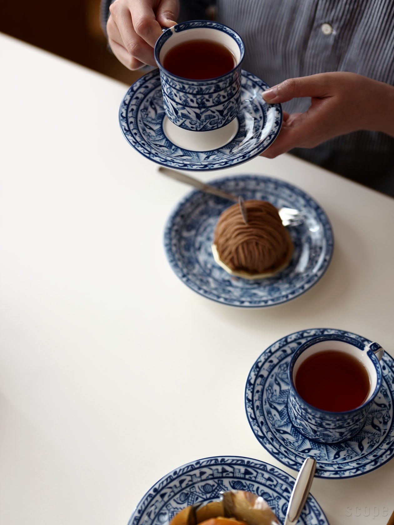 Cobolti コーヒーカップ&ソーサーを手に持って飲んでいるところ