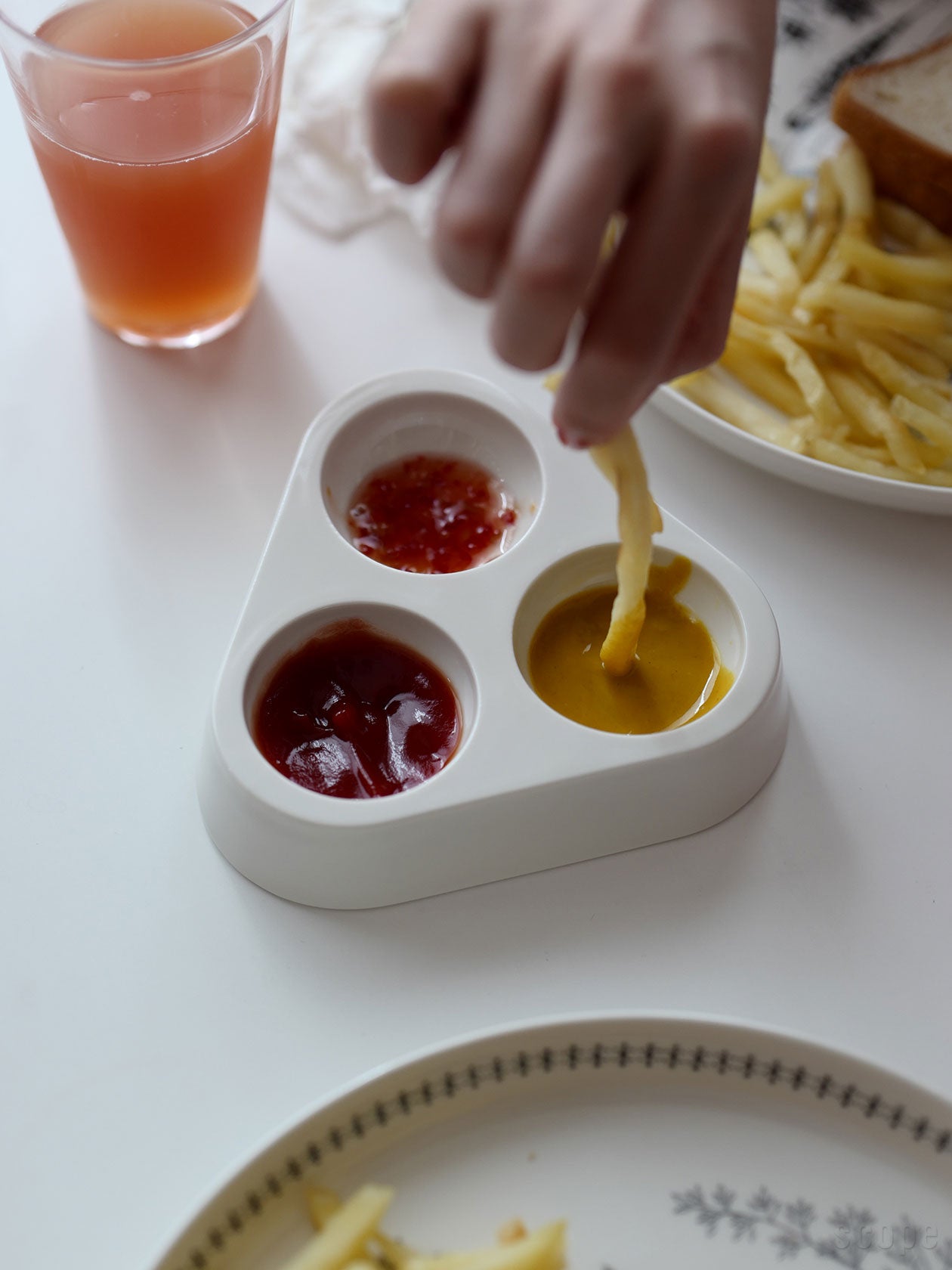 OVOにケチャップ、マスタード、スイートチリをいれ、ポテトをつけているところ